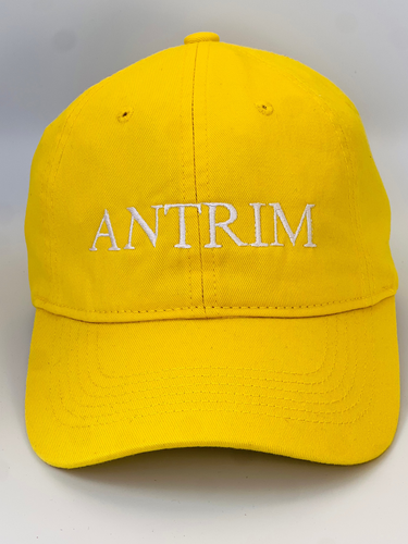 Yellow  baseball cap with 'ANTRIM' embroidered in white thread. Adjustable back strap with metal clasp.
