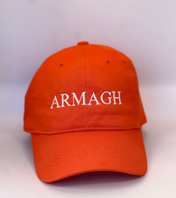 Load image into Gallery viewer, Orange baseball cap with &#39;ARMAGH&#39; in white embroidery thread. Adjustable back strap with metal clasp.
