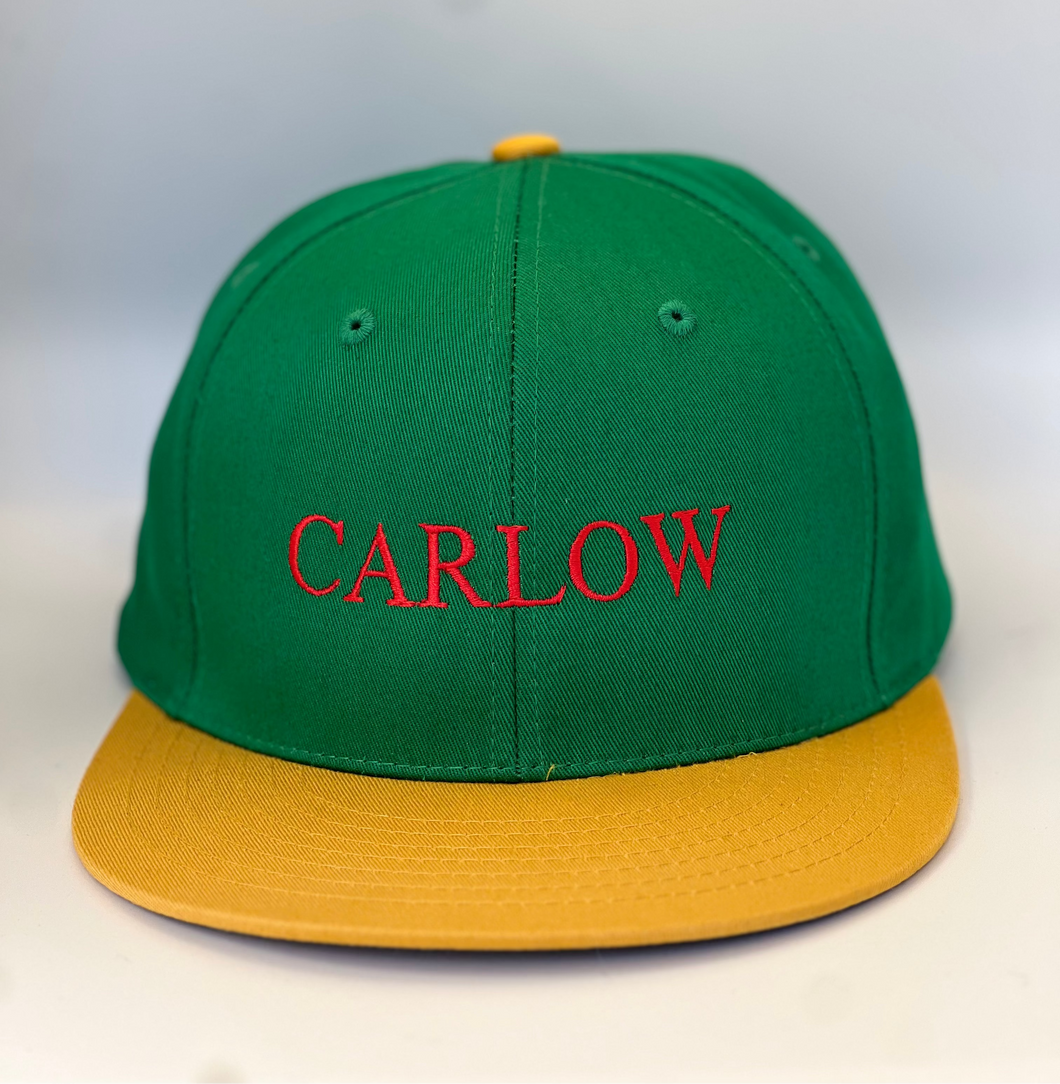 Green and  yellow  trucker style  baseball cap with plastic adjustable back strap. Carlow embroidered in red thread.