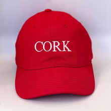 Load image into Gallery viewer, Red baseball cap with &#39;Cork&#39; embroidered in white thread. Adjustable back strap with metal clasp.
