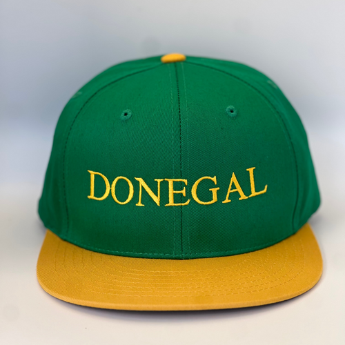 Green trucker style baseball cap with yellow trim.  'Donegal ' embroidered in yellow thread. Adjustable snap back .
