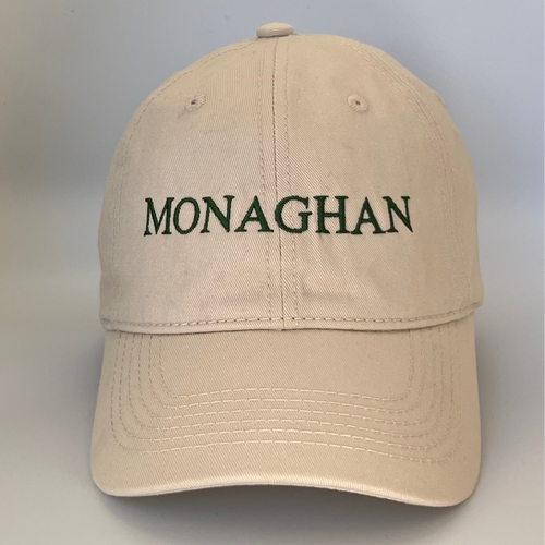 Beige cap with 'MONAGHAN' embroidered in green on a beige background