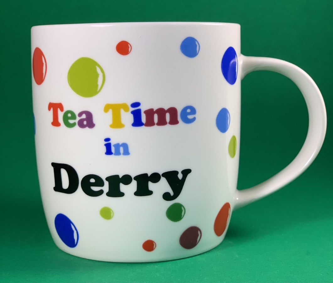 An 11oz bone china  brightly colored polka dot mug that says Teatime in Derry