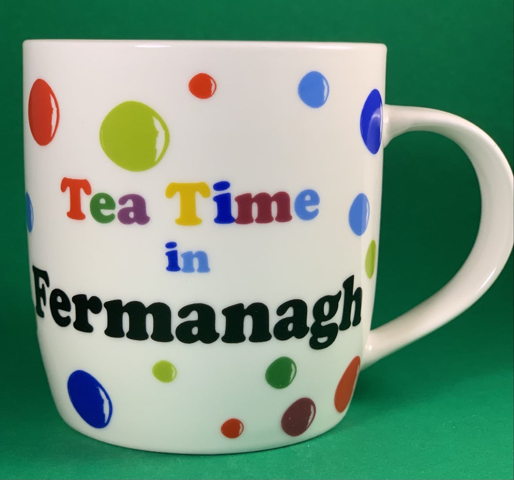 An 11oz bone china  brightly colored polka dot mug that says Teatime in Fermanagh