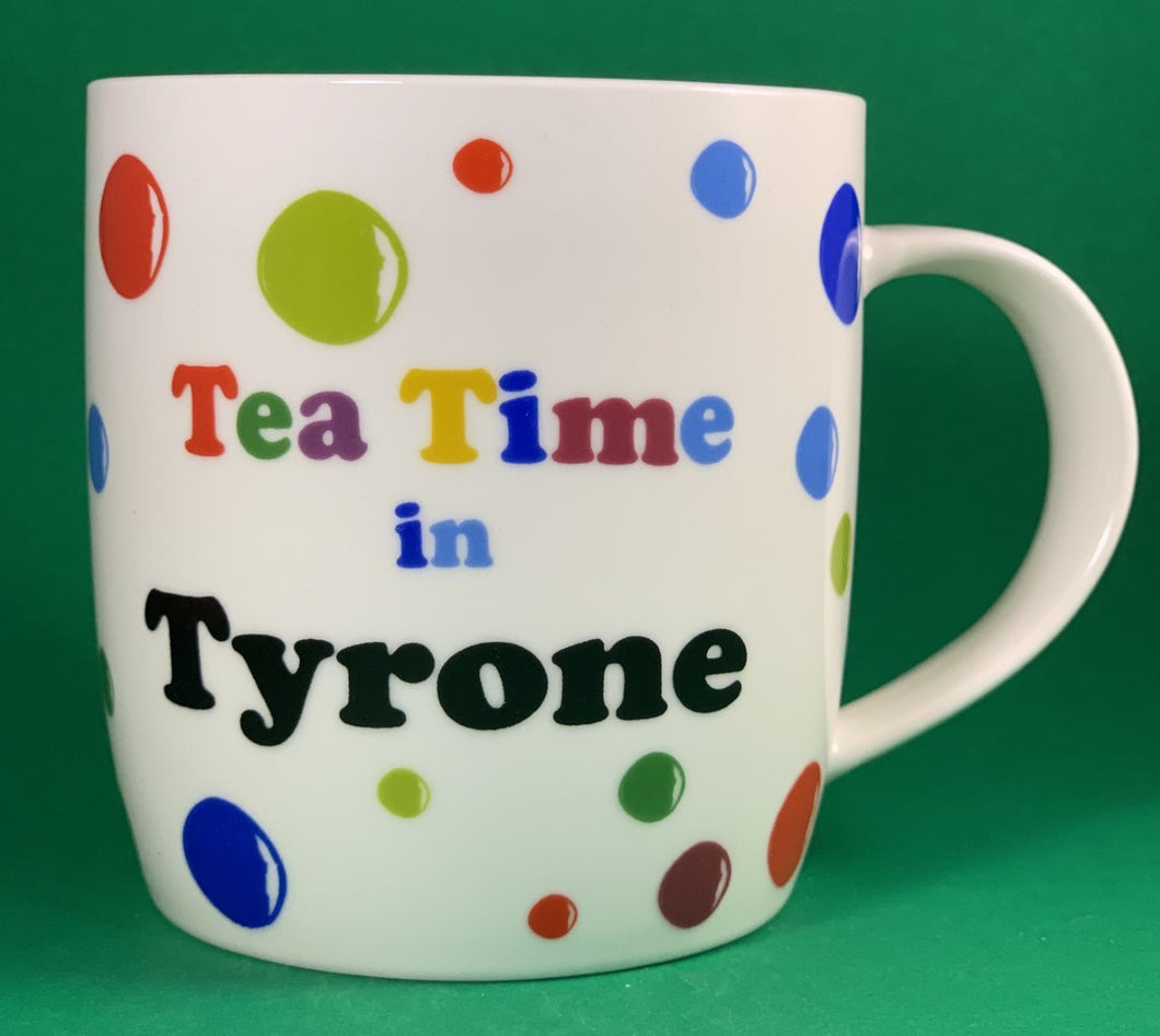 An 11oz bone china  brightly colored polka dot mug that says Teatime in Tyrone